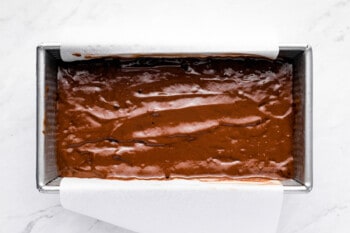 overhead view of chocolate pound cake batter in a metal loaf pan.