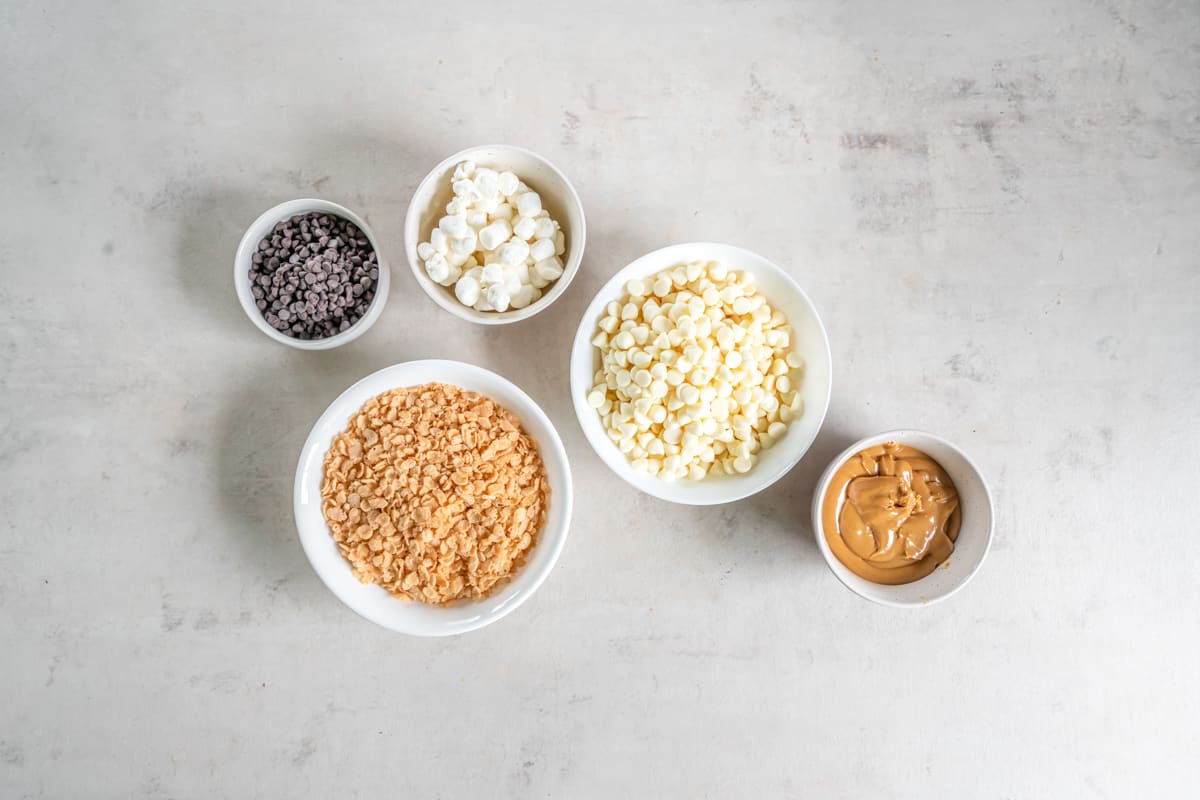 Overhead view of ingredients for avalanche cookies in white bowls.
