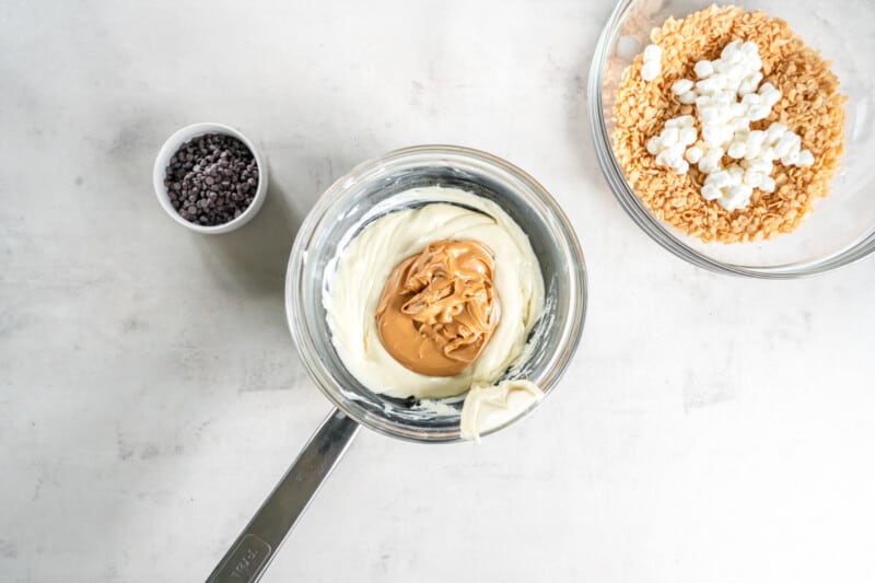 overhead view of peanut butter added to melted white chocolate in a saucepan.