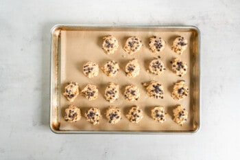 21 chocolate chip topped avalanche cookies in a baking sheet.