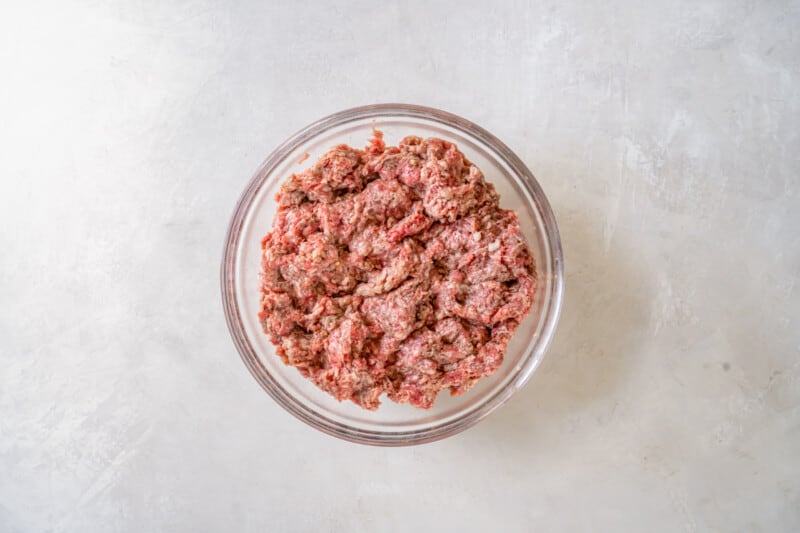 ground beef and breakfast sausage meat mixed together in a glass bowl.