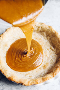pouring caramel filling into the pie crust