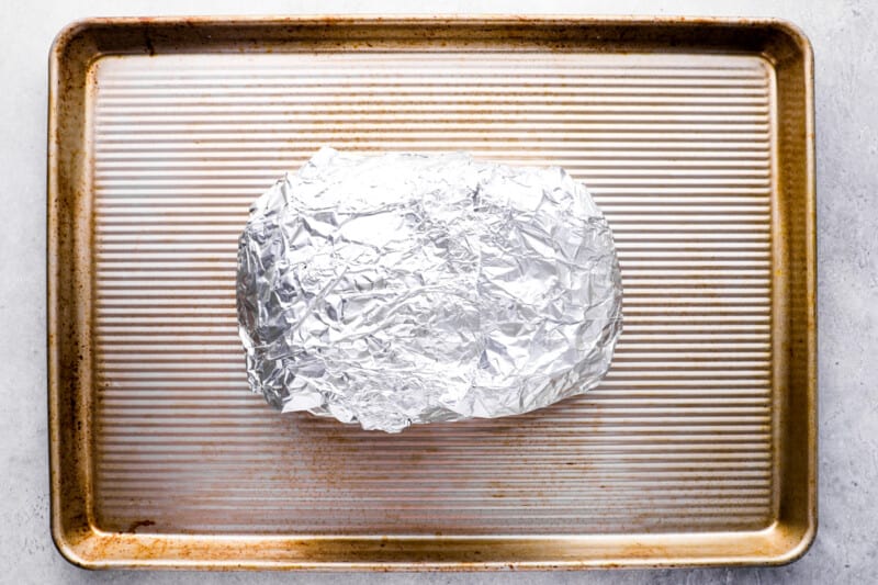 pull apart cheese bread wrapped in aluminum foil on a baking sheet.