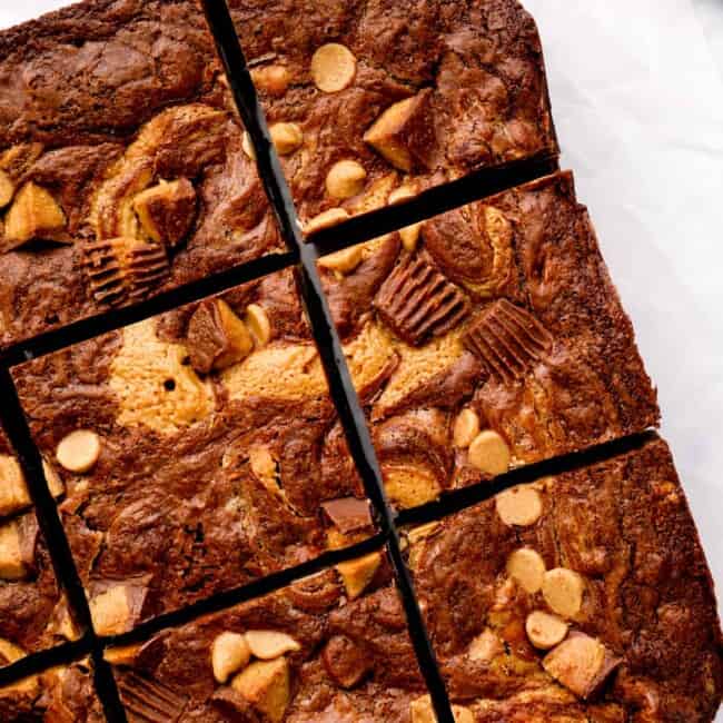 overhead view of cut peanut butter brownies on a white cutting board.