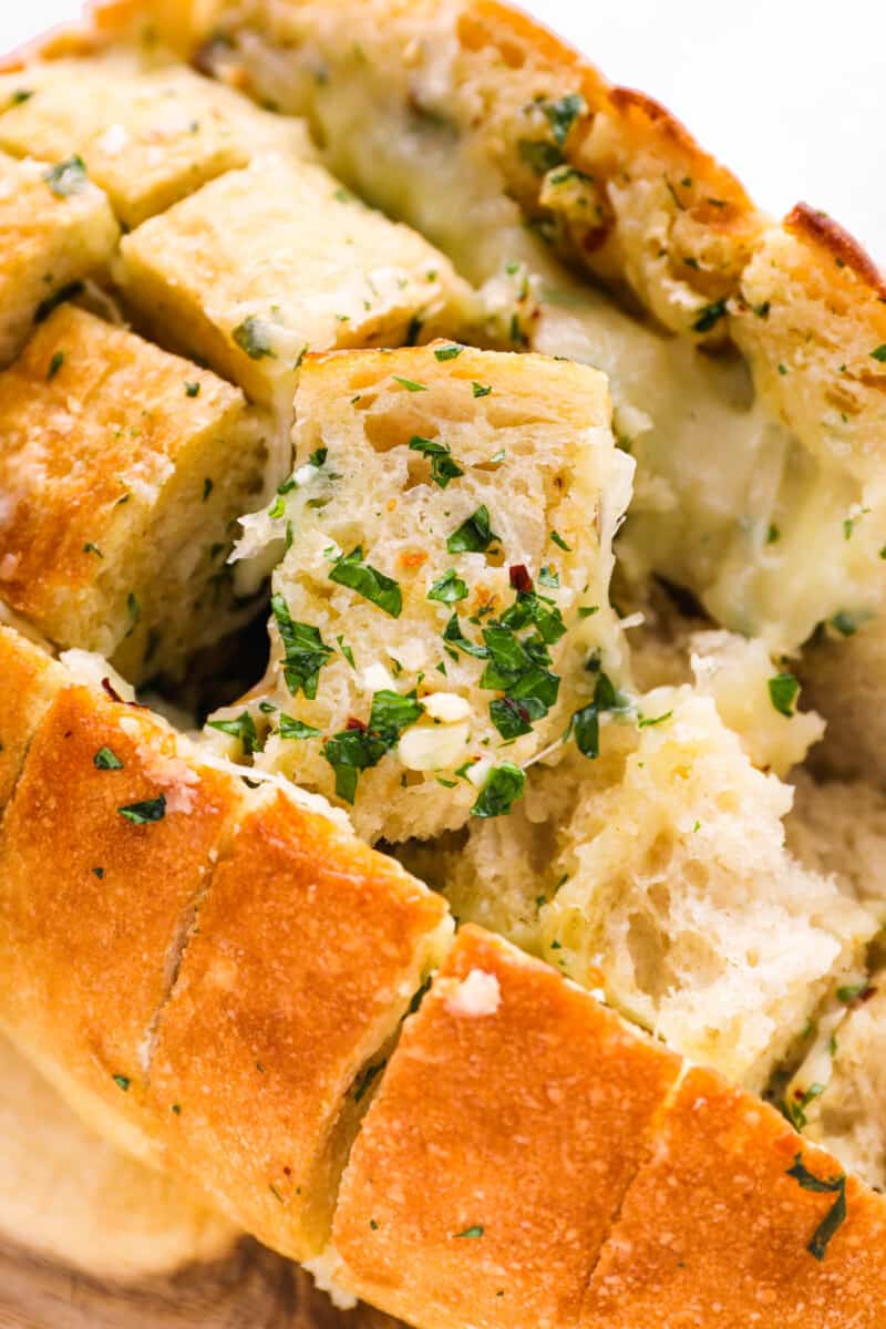 close up of pull apart cheese bread with pieces missing.