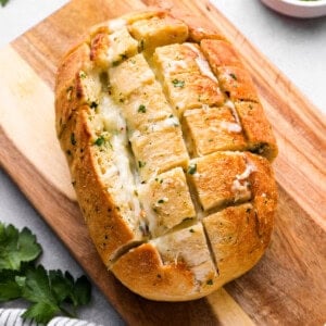 pull apart cheese bread on a wooden cutting board.