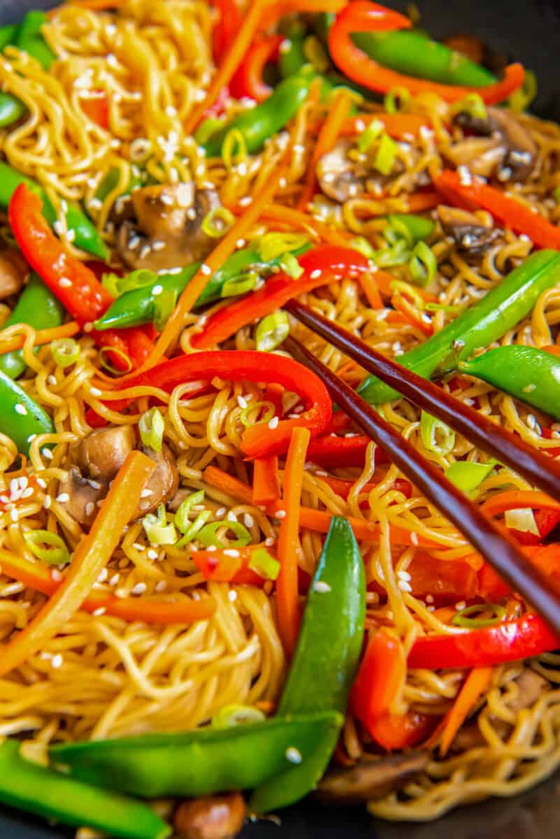 close up of vegetable lo mein with chopsticks.