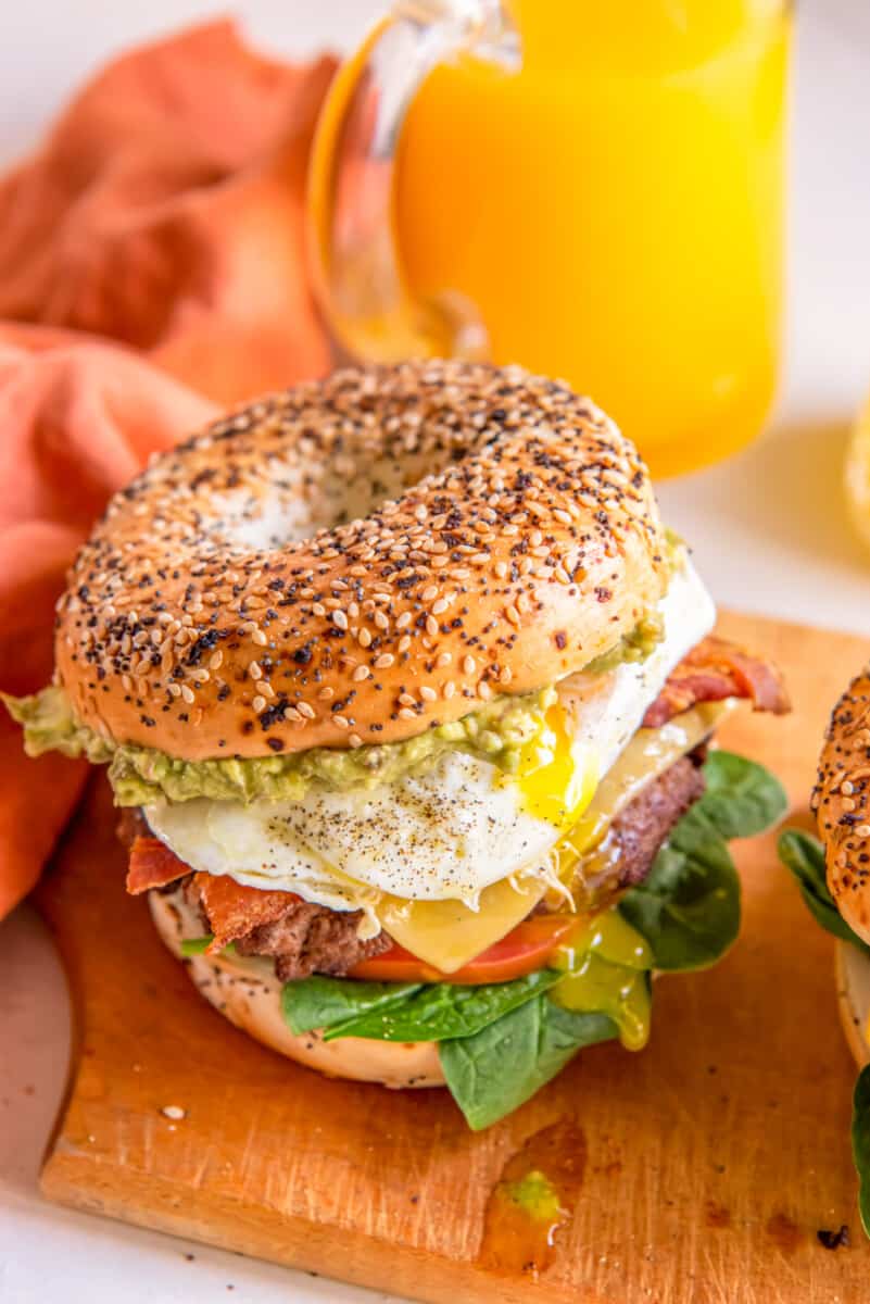 close up of a breakfast burger on a wooden cutting board.