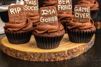 graveyard cupcakes topped with tombstone cookies that read "RIP", "IMA goner", "game over", "Be a Fraud", and "This sucks"