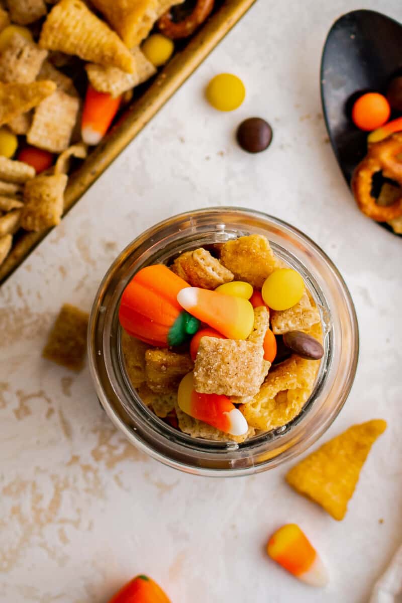 small jar filled with halloween candy Chex mix