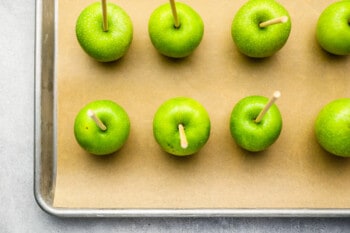 green apples with sticks inserted into the core