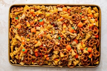 halloween snack mix ingredients piled up in a baking tray