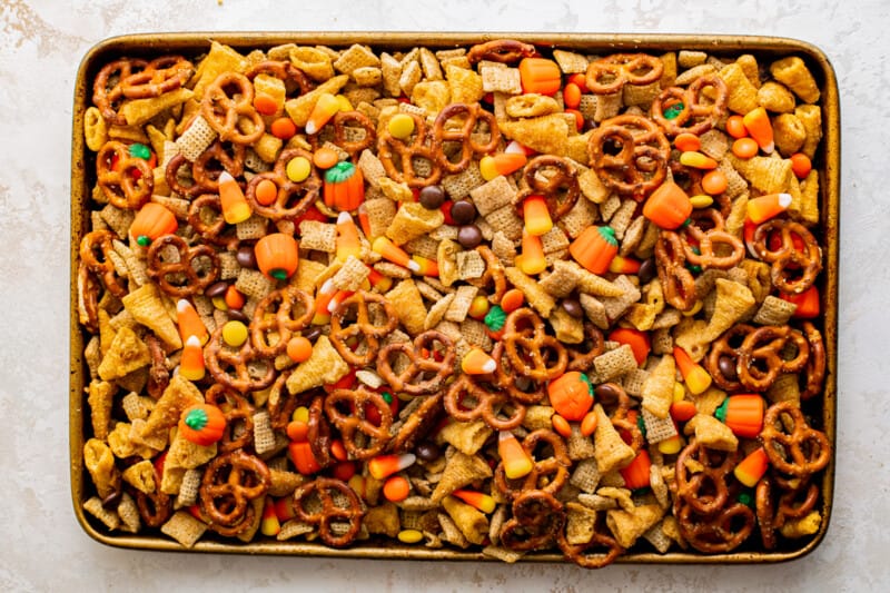 halloween snack mix ingredients piled up in a baking tray