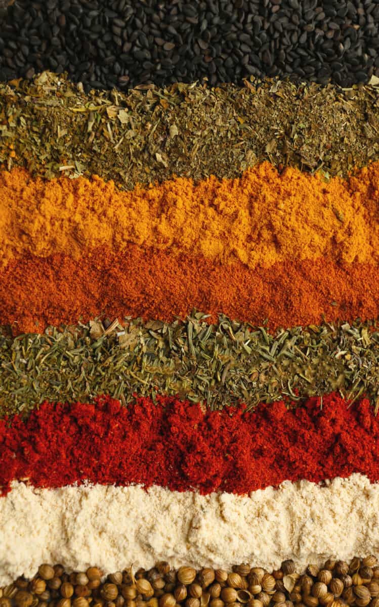 colorful ground cooking spices lined up in a gradient.