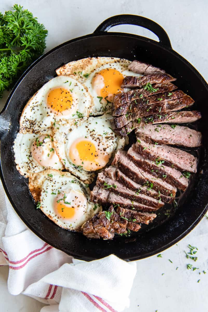 overhead view of steak and eggs in a cast iron pan.