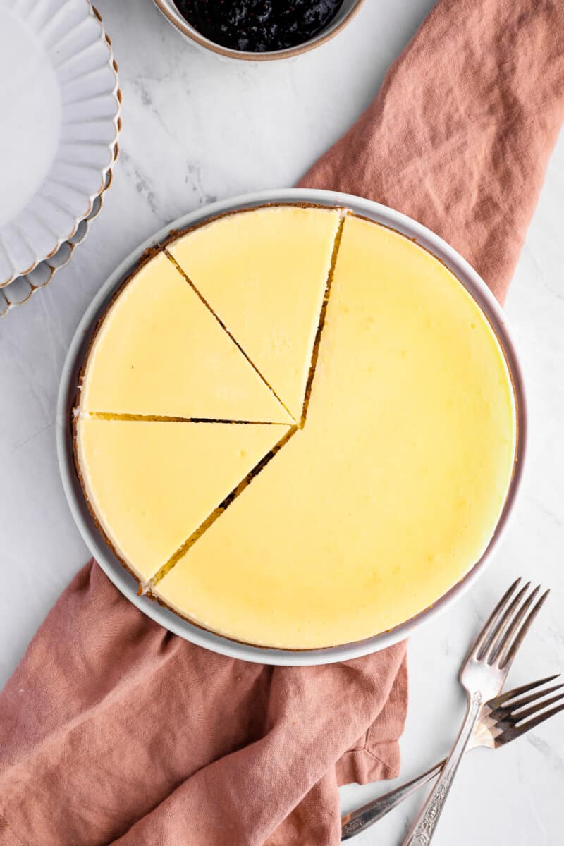 overhead view of a New York cheesecake, partially cut into slices