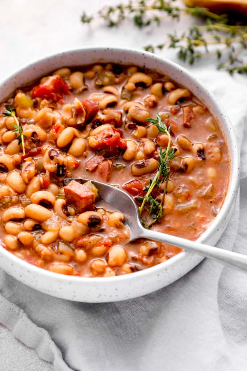 crockpot black eyed peas in a white bowl with a spoon.