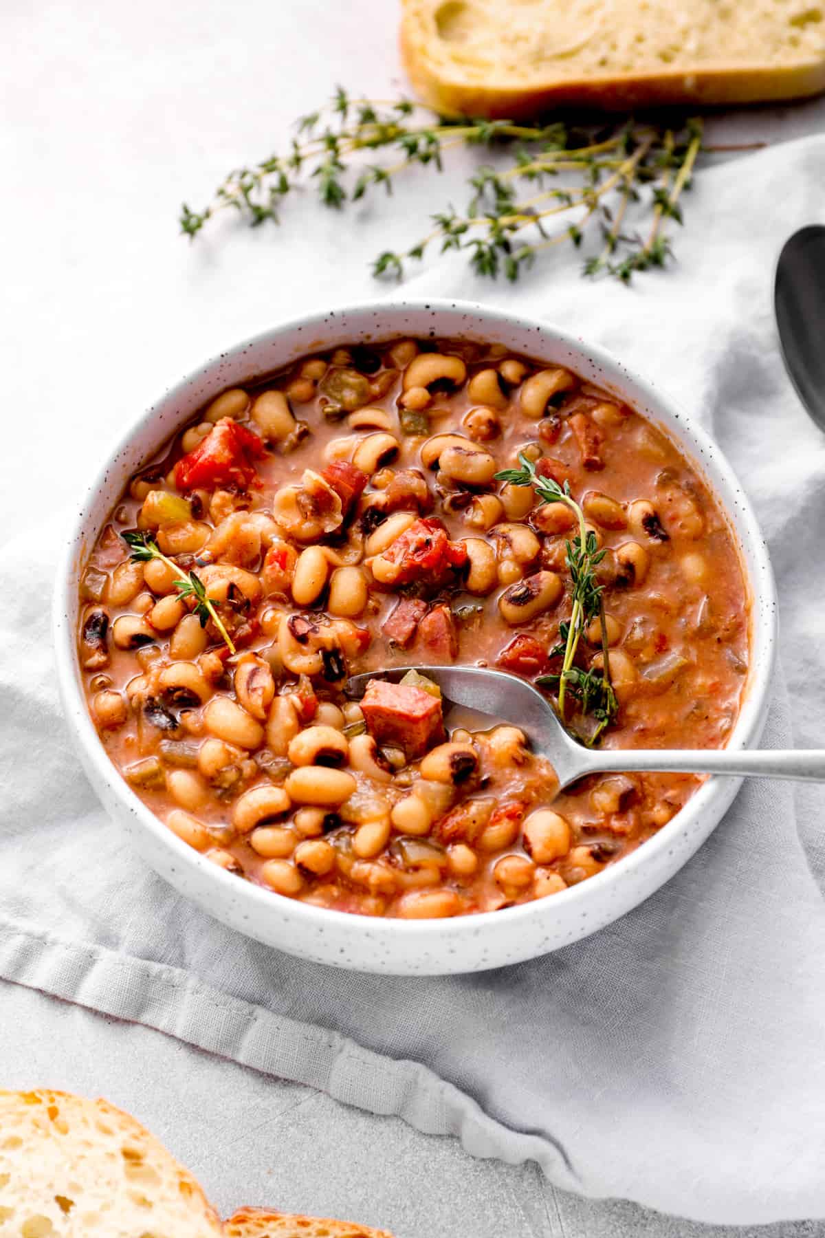 crockpot black eyed peas in a white bowl with a spoon.