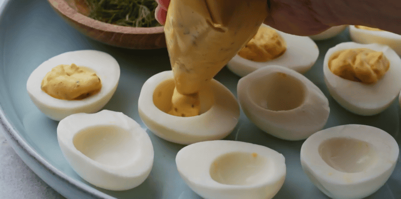 piping egg mixture into egg whites