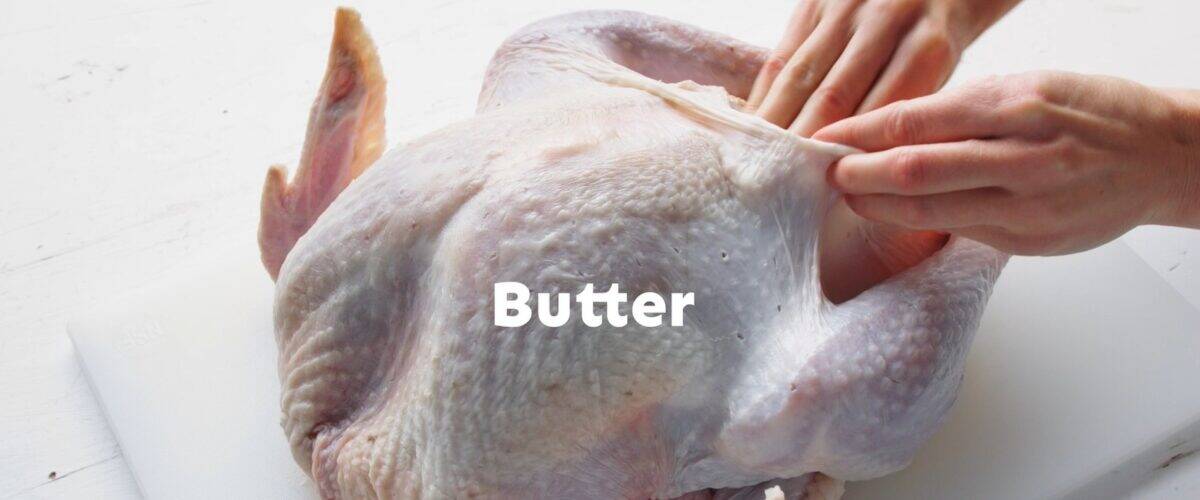 Rubbing butter under the skin of the turkey.