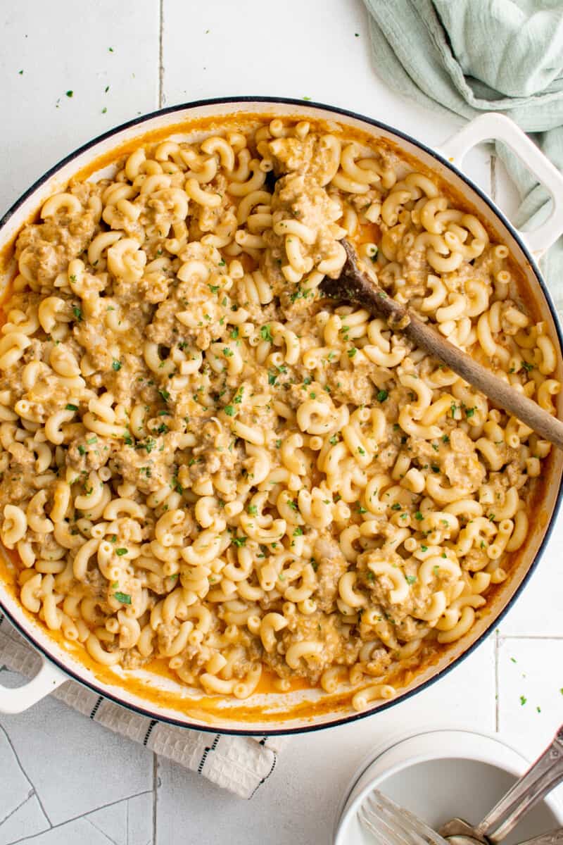 overhead view of hamburger helper in a white pan with a wooden spoon.