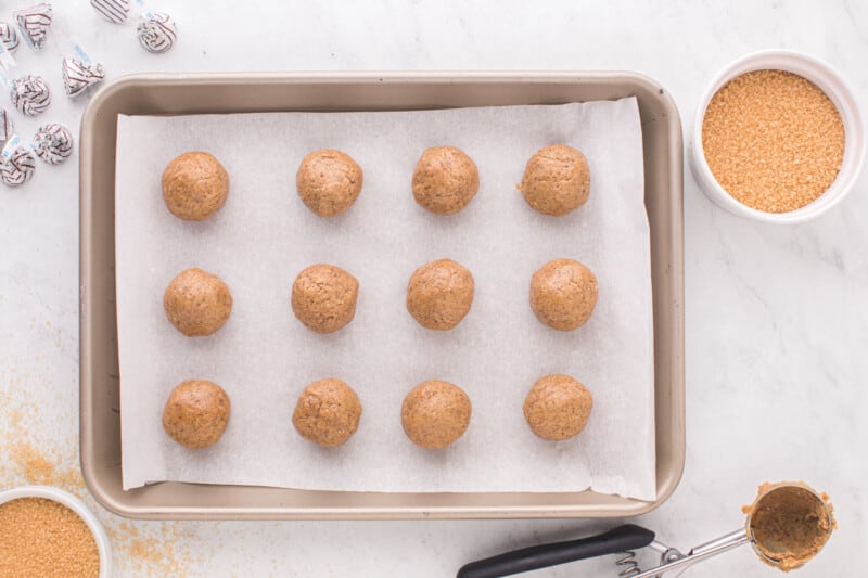 balls of cookie dough lined up on a baking sheet