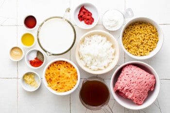 overhead view of ingredients for hamburger helper in white bowls.