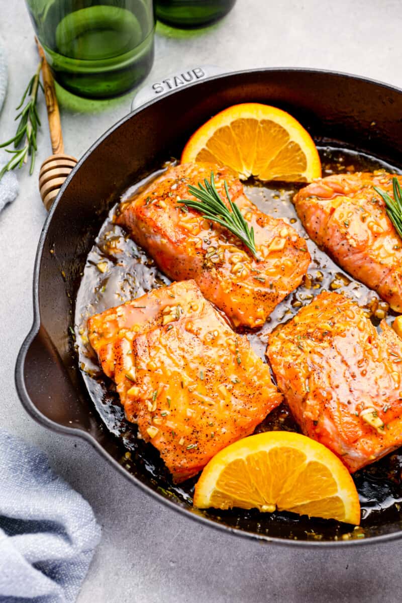 orange glazed salmon in a cast iron skillet