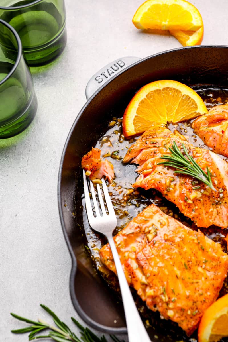 fork laying in a skillet of salmon