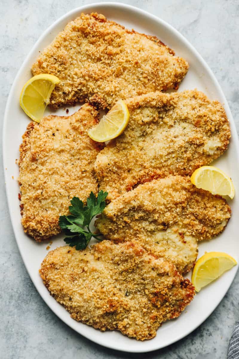 serving platter full of parmesan crusted chicken breasts