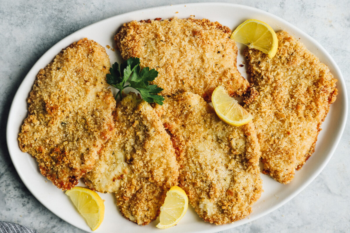 serving platter full of parmesan crusted chicken breasts