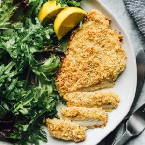 dinner plate with parmesan crusted chicken breast and greens