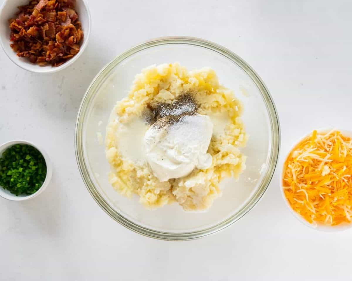 Adding seasonings to the mashed potatoes.