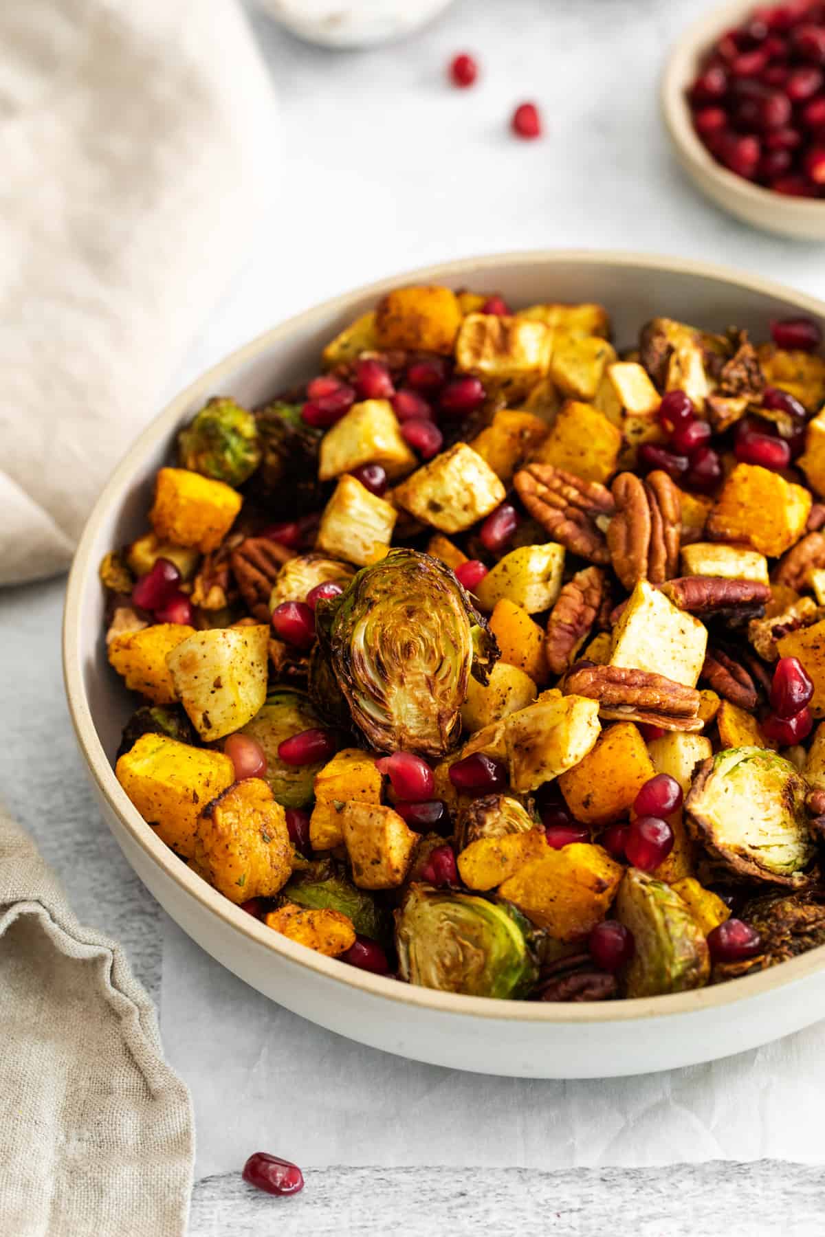 bowl of roasted Brussels sprouts, butternut squash, parsnips, pecans, and pomegranate seeds