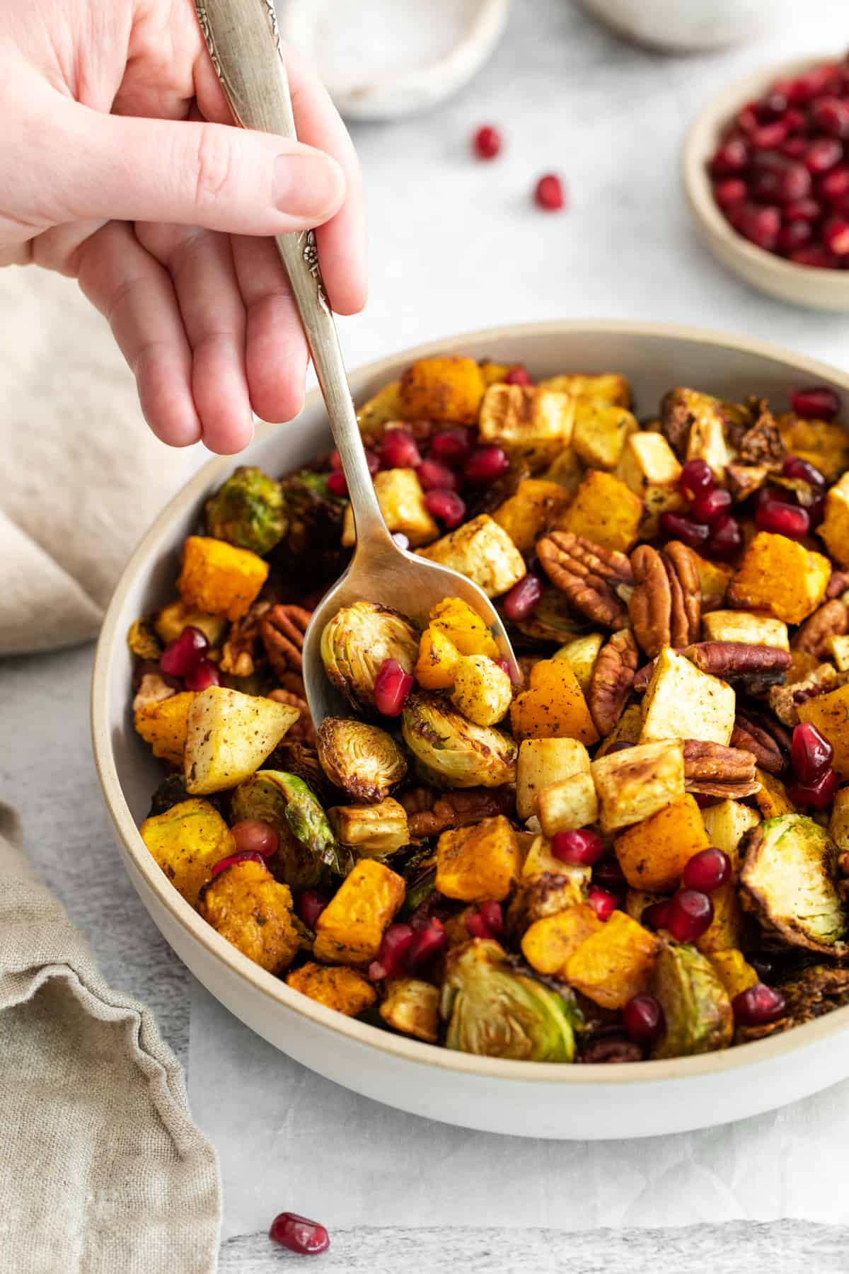 scooping into a bowl of air fryer roasted vegetables