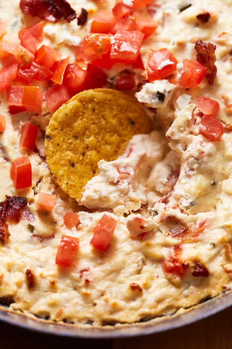 close up on a chip in hot bacon feta dip