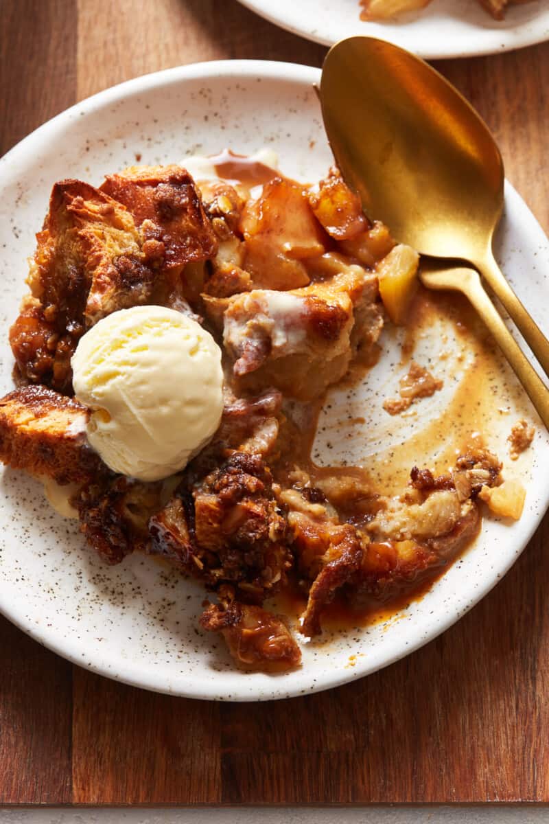 a plate of caramel apple bread pudding with a scoop of ice cream
