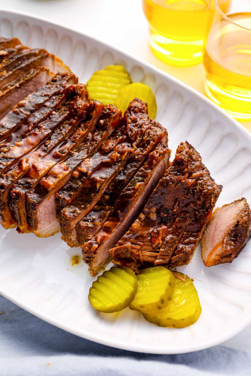 crockpot brisket sliced thinly, on a plate with pickles