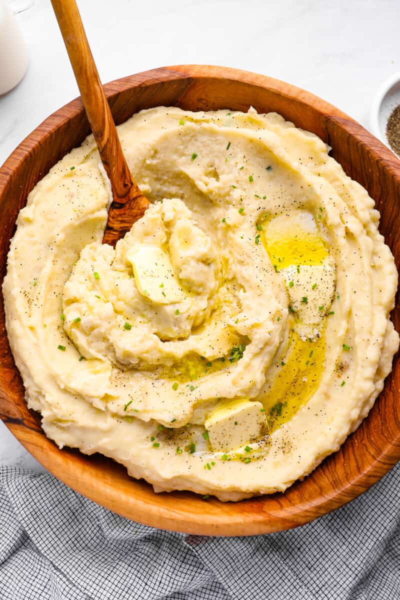 creamy crockpot mashed potatoes in a wooden serving bowl
