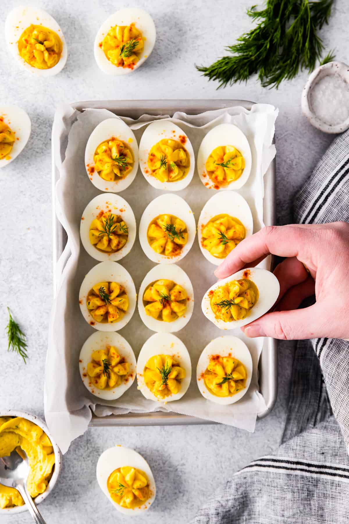 hand picking up a deviled egg from the tray