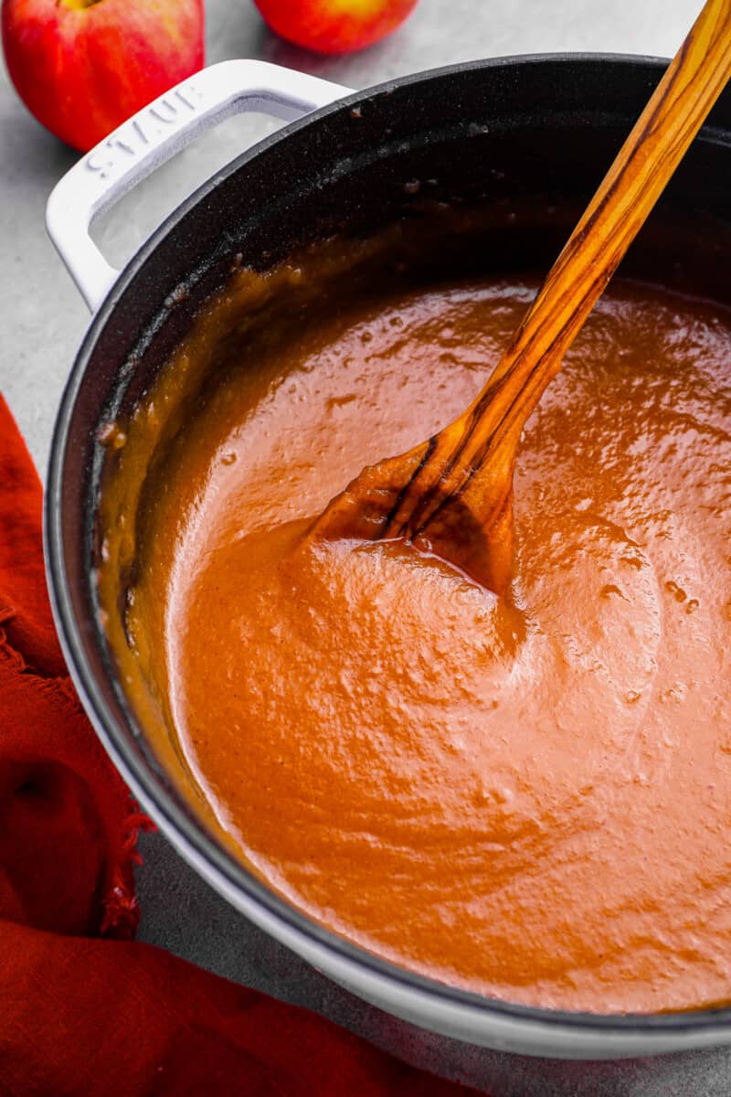 a pot of apple butter with a wooden spoon