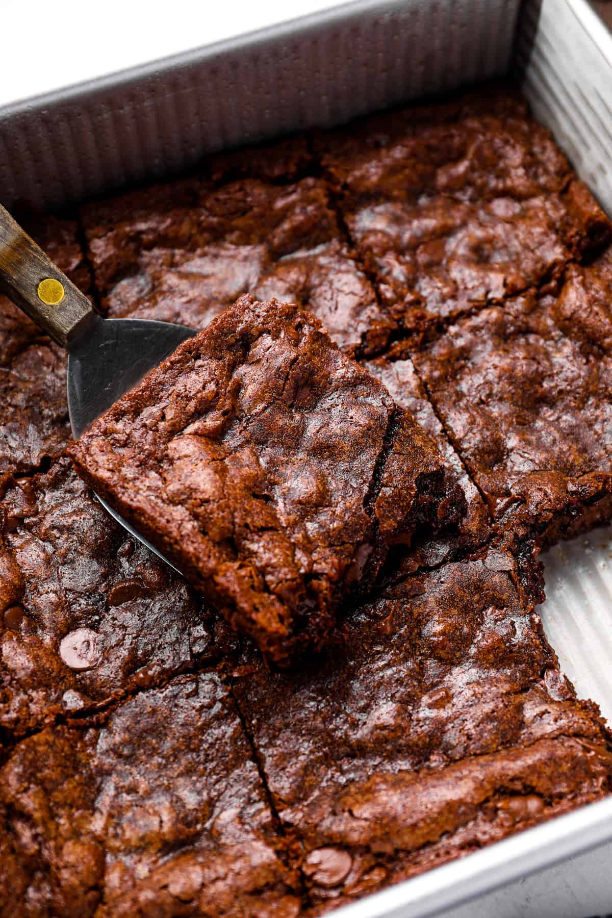close up of cut brownies in a baking pan.