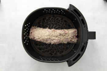 tenderloin in the basket of an air fryer, before cooking