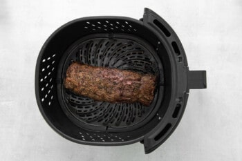 beef tenderloin in the basket of an air fryer