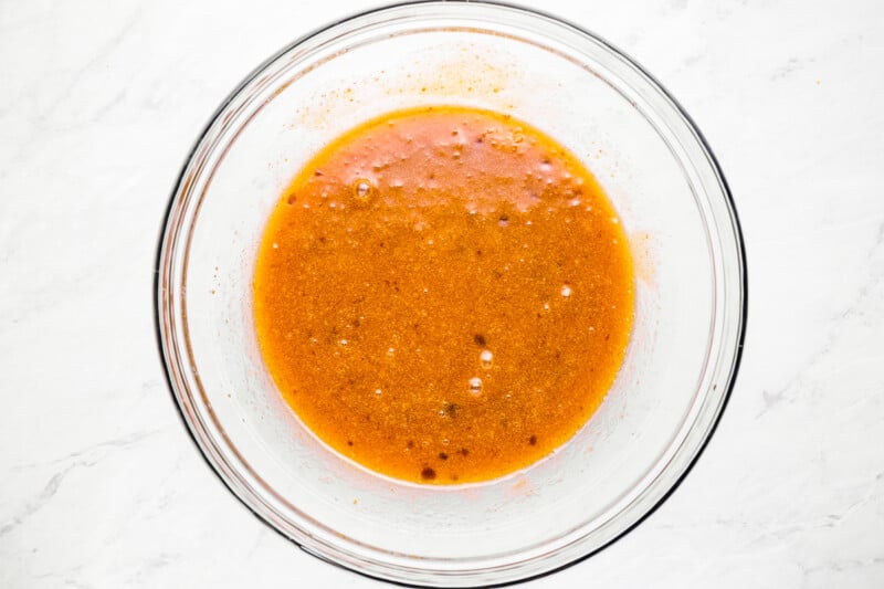 a bowl filled with sauce on a marble countertop.