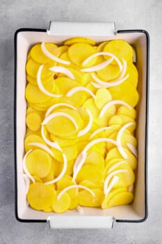 layers of potatoes and onions in a 9x13 baking pan.