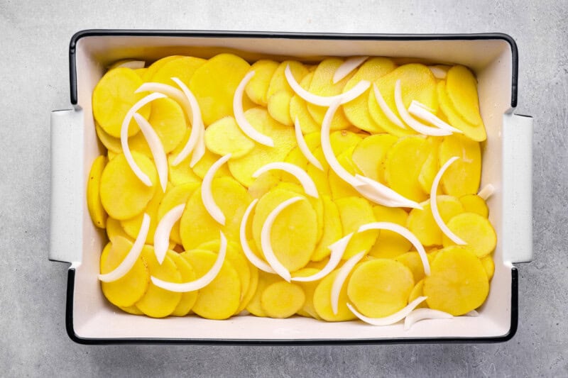 layers of potatoes and onions in a 9x13 baking pan.