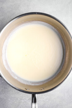cream sauce for au gratin potatoes in a saucepan.