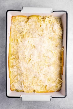 parmesan cheese sprinkled over au gratin potatoes in a 9x13 baking pan.