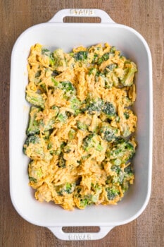 unbaked broccoli cheese casserole in a white baking pan.